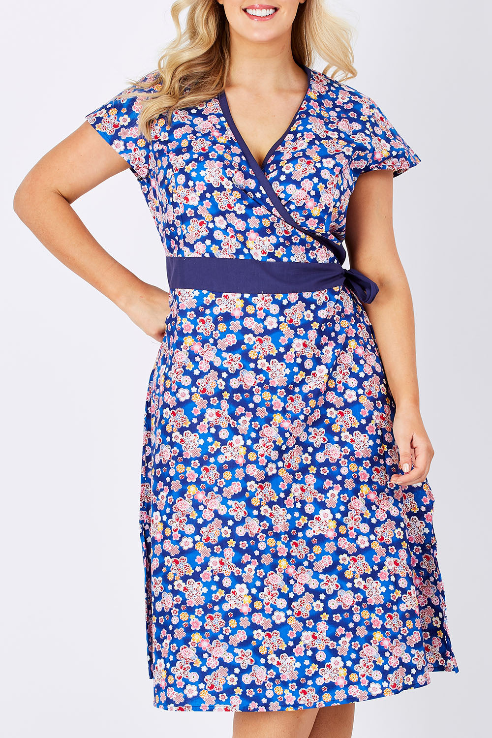 Model Jess wearing size L of the Leela Cotton Wrap Dress in colour Sakura (Blue), from the front, cropped image