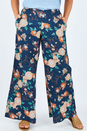 Model Abby wearing size L of the Sarita Pant in colour Maya (Blue), from the front, cropped image