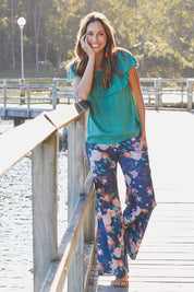 Model Amanda wearing size S of the Sarita Pant in colour Maya (Blue), from the front, showing the whole outfit