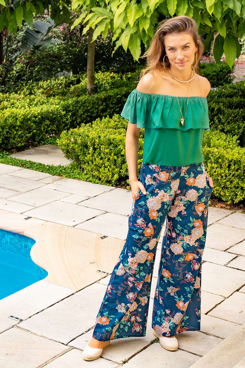 A model wearing the Sarita Pant in colour Maya (Blue), from the front, showing the whole outfit