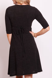 A model wearing the Maree Cross Bust Dress W Tie in colour DkCharcoal (Black), from the back