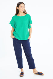 Model Cara wearing size S of the Preloved Cotton Linen Woven Top in colour Jade (Green), from the front, showing the whole outfit