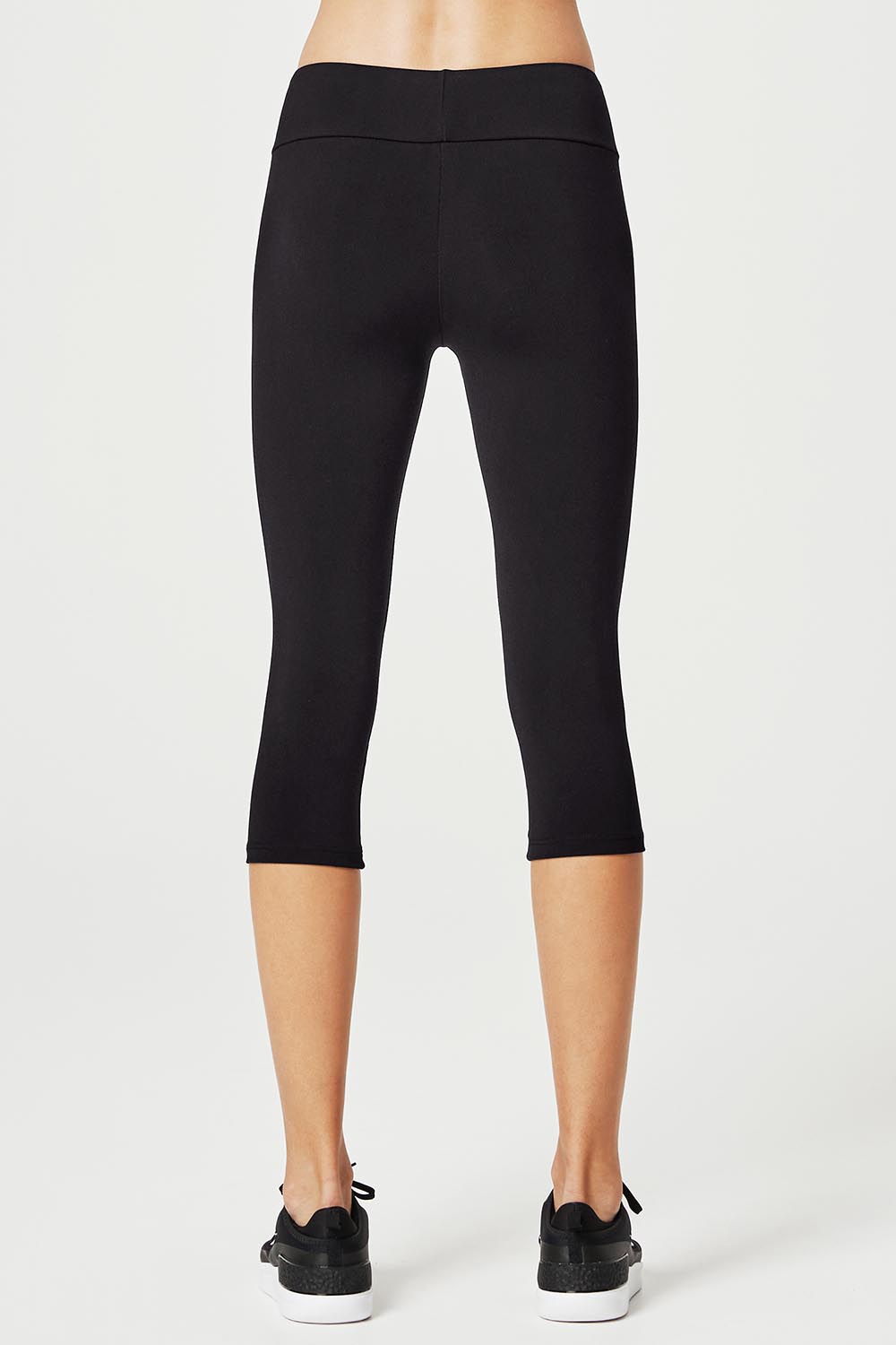 A model wearing the High Rise 3/4 Tight in colour Black (Black), from the back