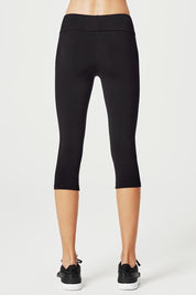A model wearing the High Rise 3/4 Tight in colour Black (Black), from the back