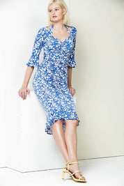A model wearing the Somerland Ruched Dress in colour Bluedaisy (Blue), from the front, showing the whole outfit