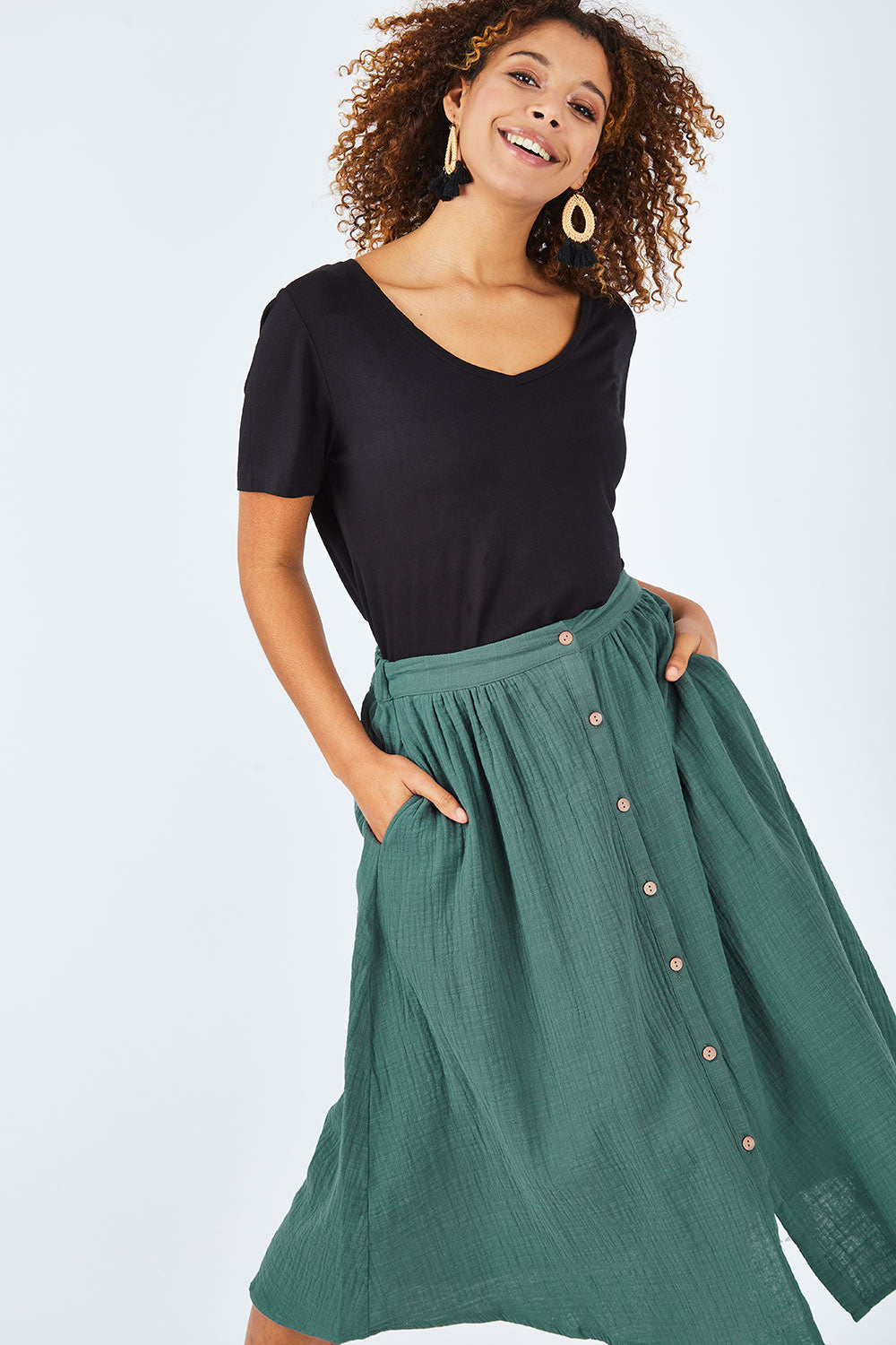 Model Summer wearing size 10 of the Lost Dreams Buttoned Skirt in colour Forest (Green), from the front, cropped image
