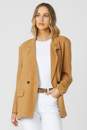 A model wearing the Alexis Blazer in colour Toffee, from the front, cropped image
