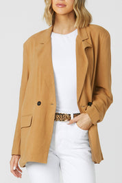 A model wearing the Alexis Blazer in colour Toffee, from the front, cropped image