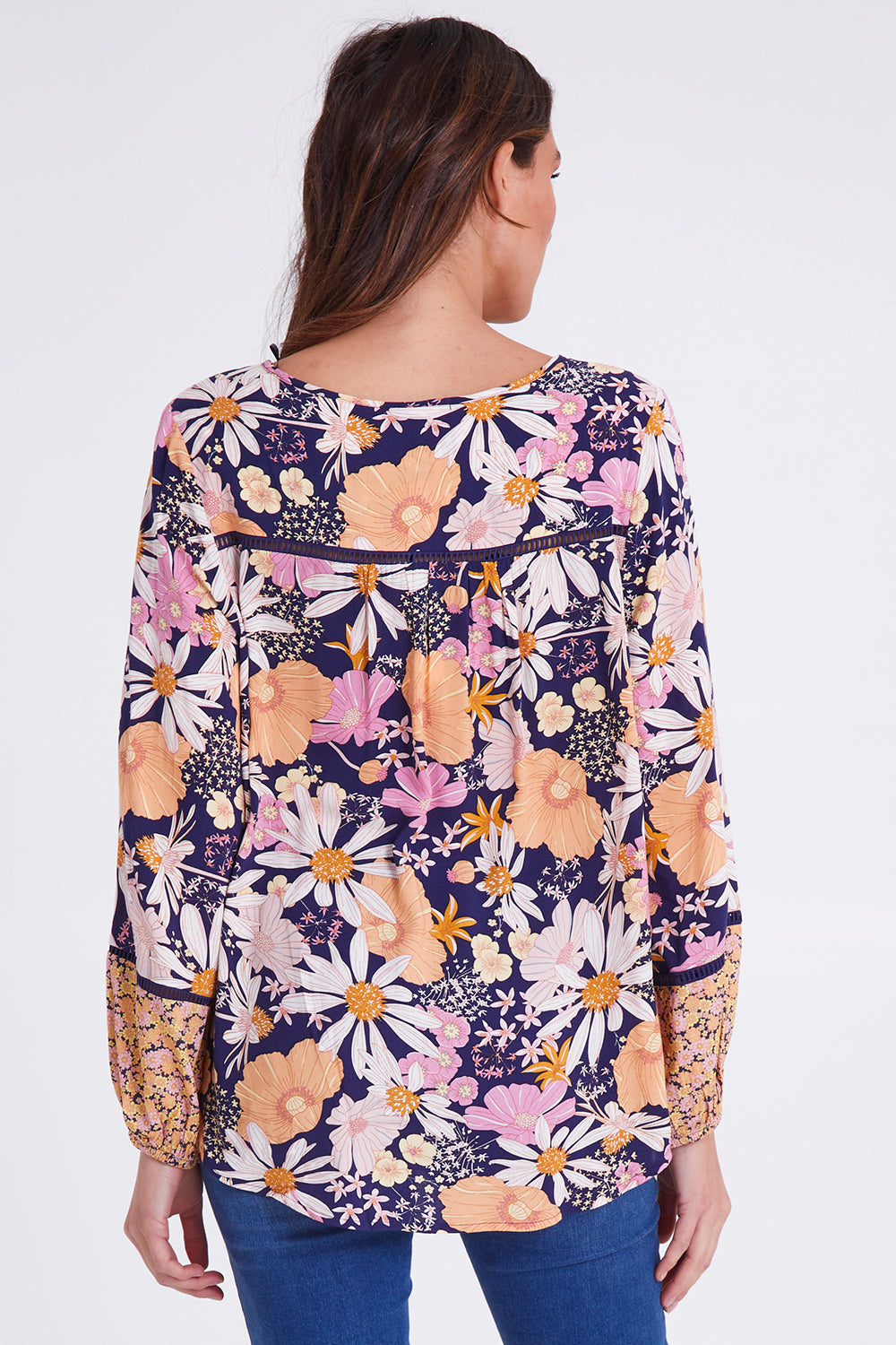 Model Madeline wearing size 10 of the Montana Boho Blouse in colour Navyfloral (Blue), from the back