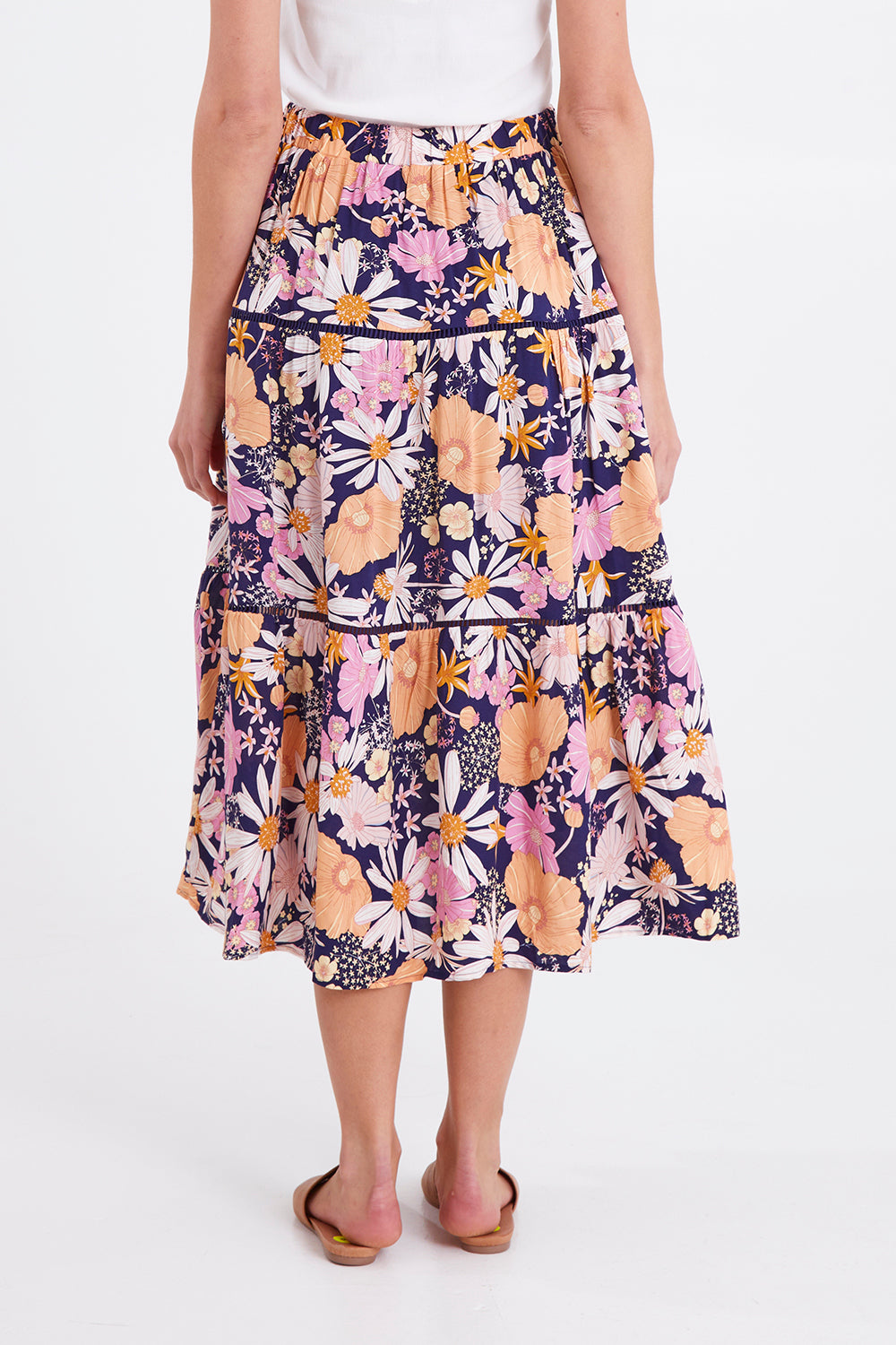 Model Madeline wearing size 10 of the Montana Tiered Skirt in colour Navyfloral (Blue), from the back