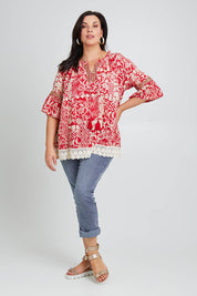 Model Poppy wearing size 16 of the Maroubra Beach Cotton Blouse in colour Red (Red), from the front, showing the whole outfit