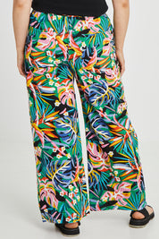 Model Keeara wearing size 16 of the Stella Print Pant in colour Rainforest (Blue), from the back