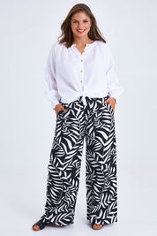 Model Monique wearing size 14 of the Stella Print Pant in colour Vines (Black), from the front, showing the whole outfit
