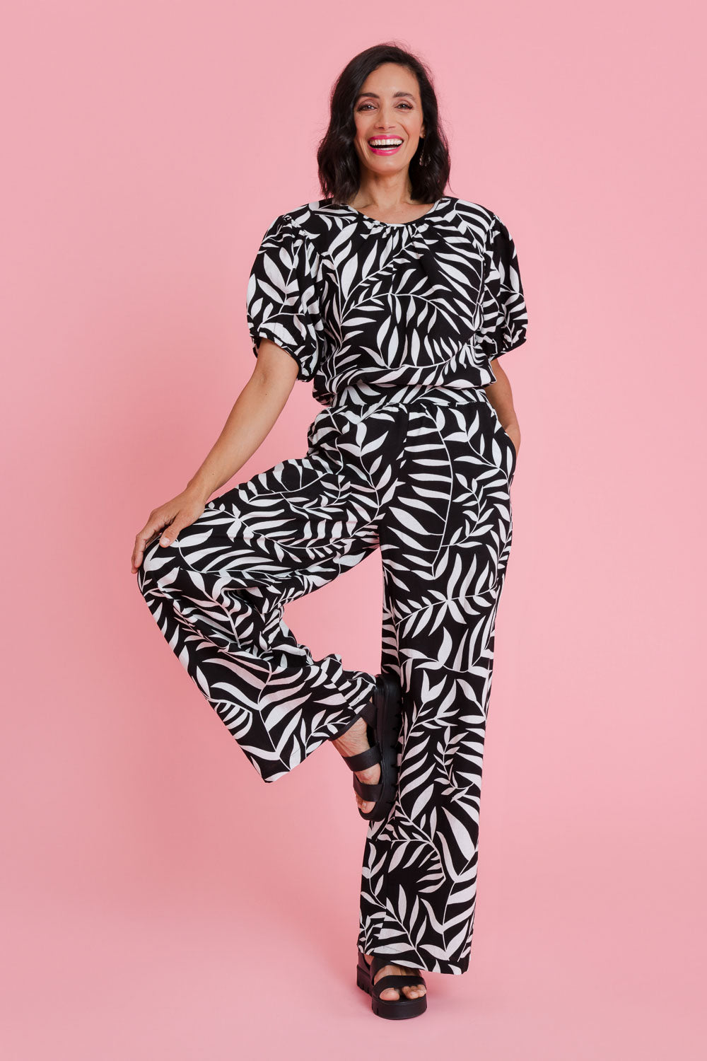 Model Natalie wearing size 10 of the Stella Print Pant in colour Vines (Black), from the front, showing the whole outfit