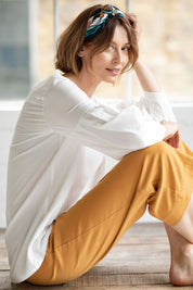 A model wearing the Benetta Blouse in colour White (White), from the front, showing the whole outfit