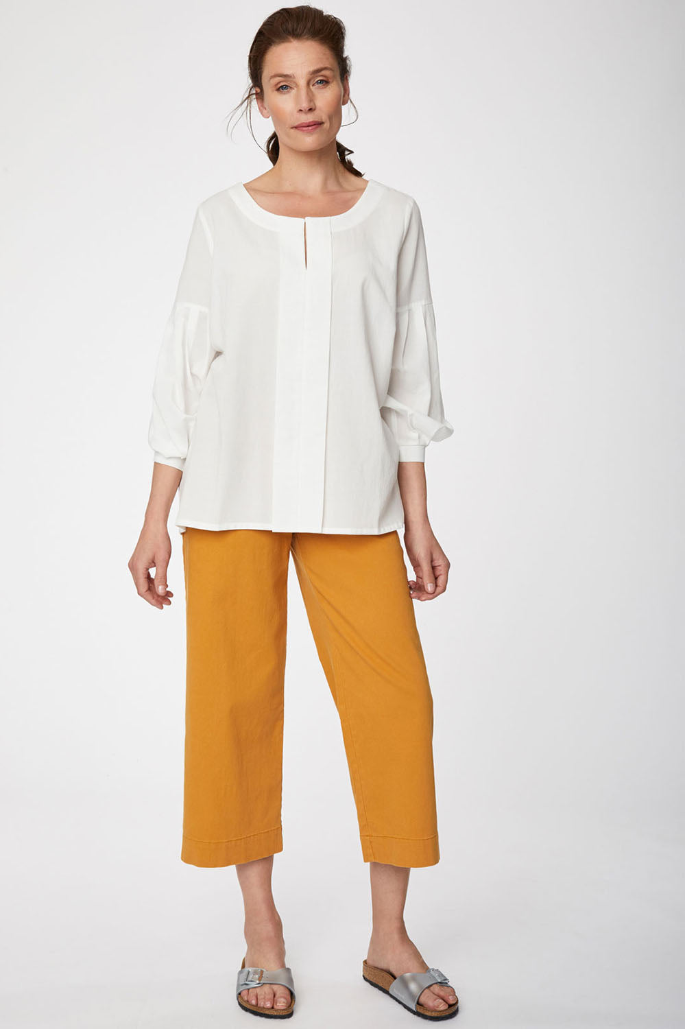 A model wearing the Benetta Blouse in colour White (White), from the front, showing the whole outfit