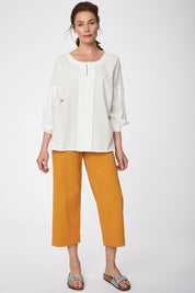 A model wearing the Benetta Blouse in colour White (White), from the front, showing the whole outfit