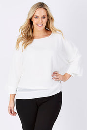 Model Jess wearing size M of the Layer Top in colour White (White), from the front, cropped image