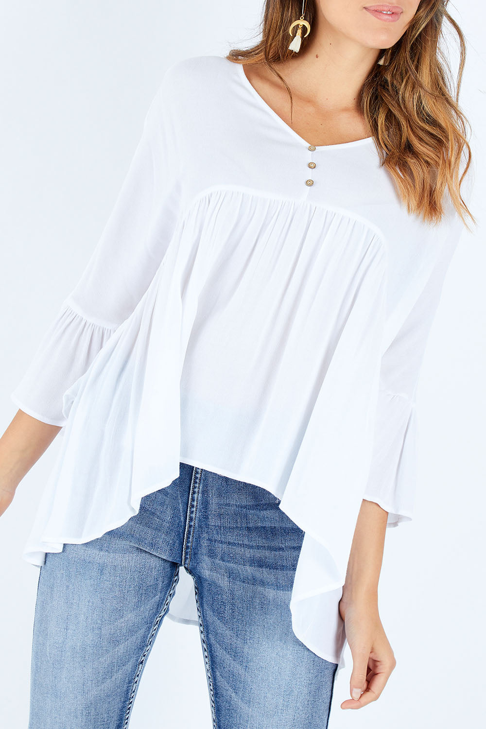 Model Madeline wearing size S of the Ruffle Hem Top in colour White (White), from the front, cropped image