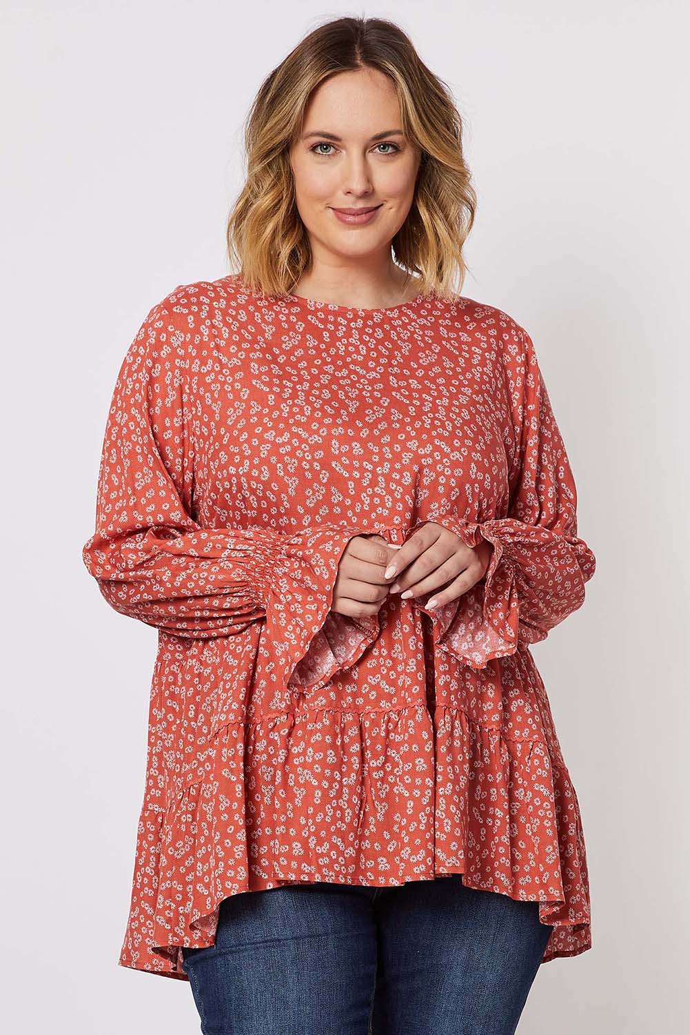 A model wearing the Floral Print Top in colour Orange, from the front, cropped image