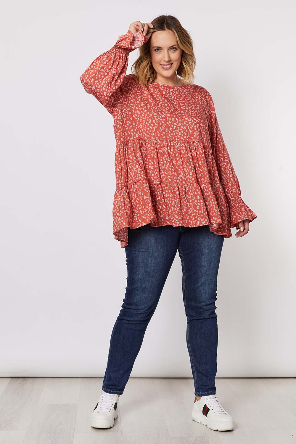 A model wearing the Floral Print Top in colour Orange, from the front, showing the whole outfit