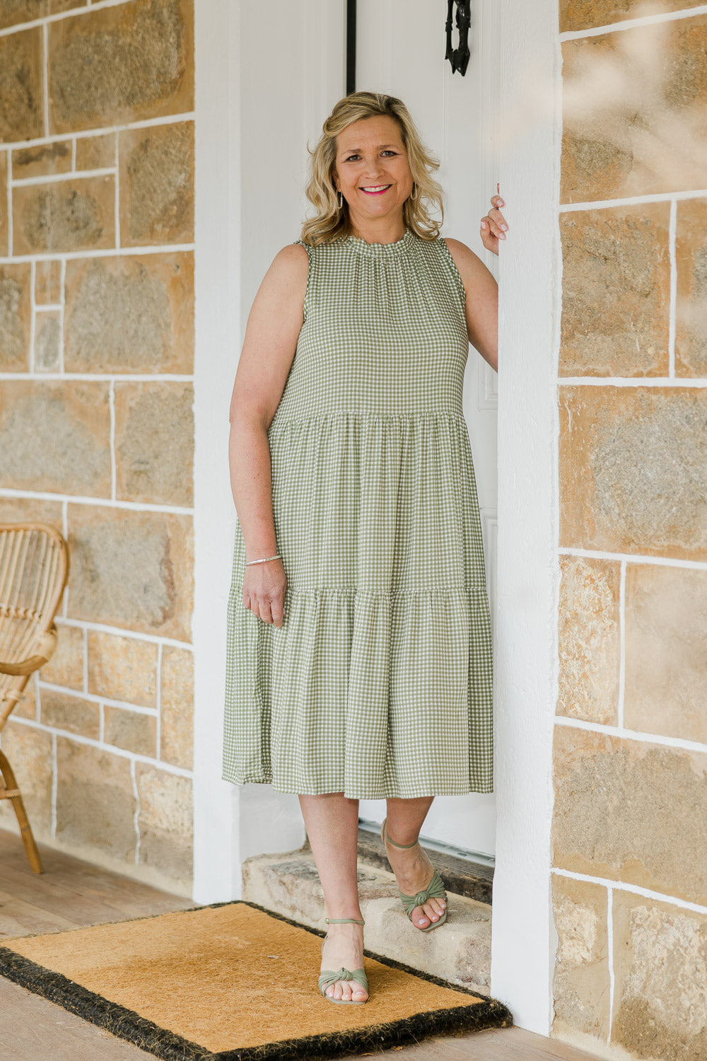 Model Chereen wearing size L of the Gingham Reversible Dress in colour Thyme (Green), from the front, showing the whole outfit