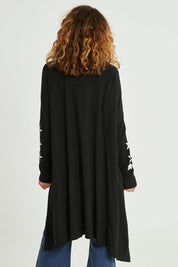 Model Emma wearing size S of the Longline Cardi in colour Black (Black), from the back