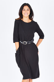 Model Gemma wearing size S of the Curved Seam Dress in colour Black (Black), from the front, cropped image