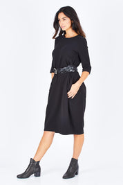 Model Gemma wearing size S of the Curved Seam Dress in colour Black (Black), from the front, showing the whole outfit