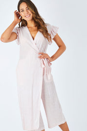 Model Madeline wearing size S of the Sunset Jumpsuit in colour Whitewild (White), from the front, cropped image