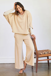 Model Amanda wearing the Cotton Terry Batwing Sweater in colour Porridge, from the front, showing the whole outfit