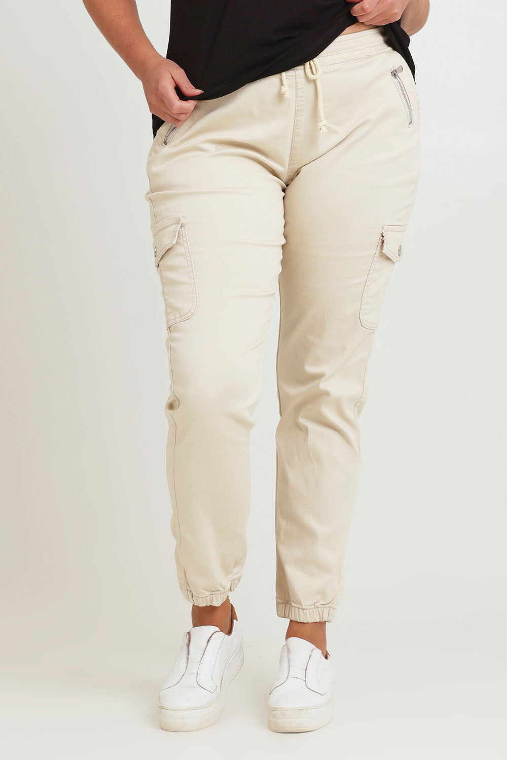 Model Chanel wearing size 16 of the Harlow Cargo Jogger in colour Beige, from the front, cropped image