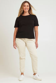 Model Chanel wearing size 16 of the Harlow Cargo Jogger in colour Beige, from the front, showing the whole outfit
