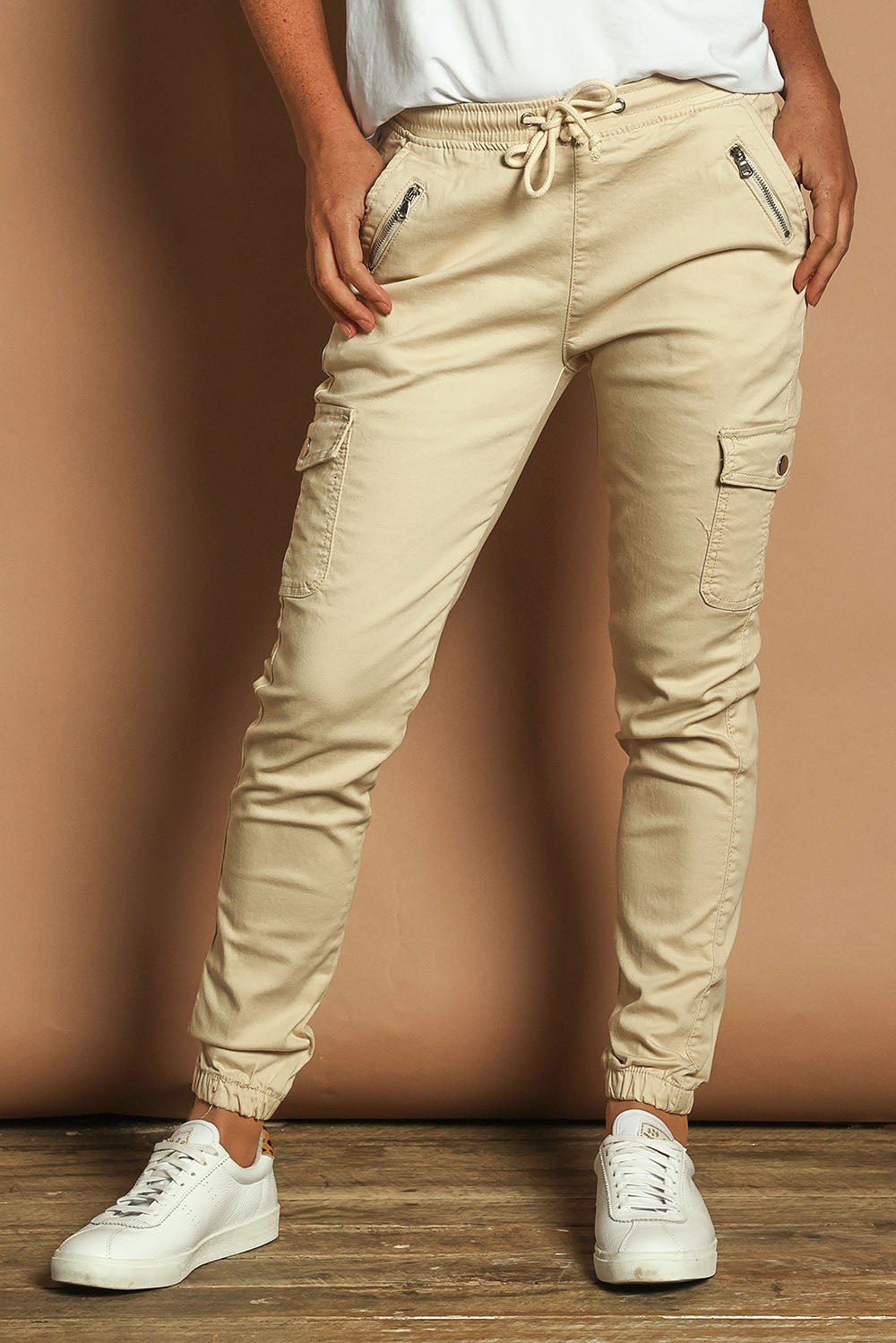 Model Katie wearing size 10 of the Harlow Cargo Jogger in colour Beige, from the front, cropped image