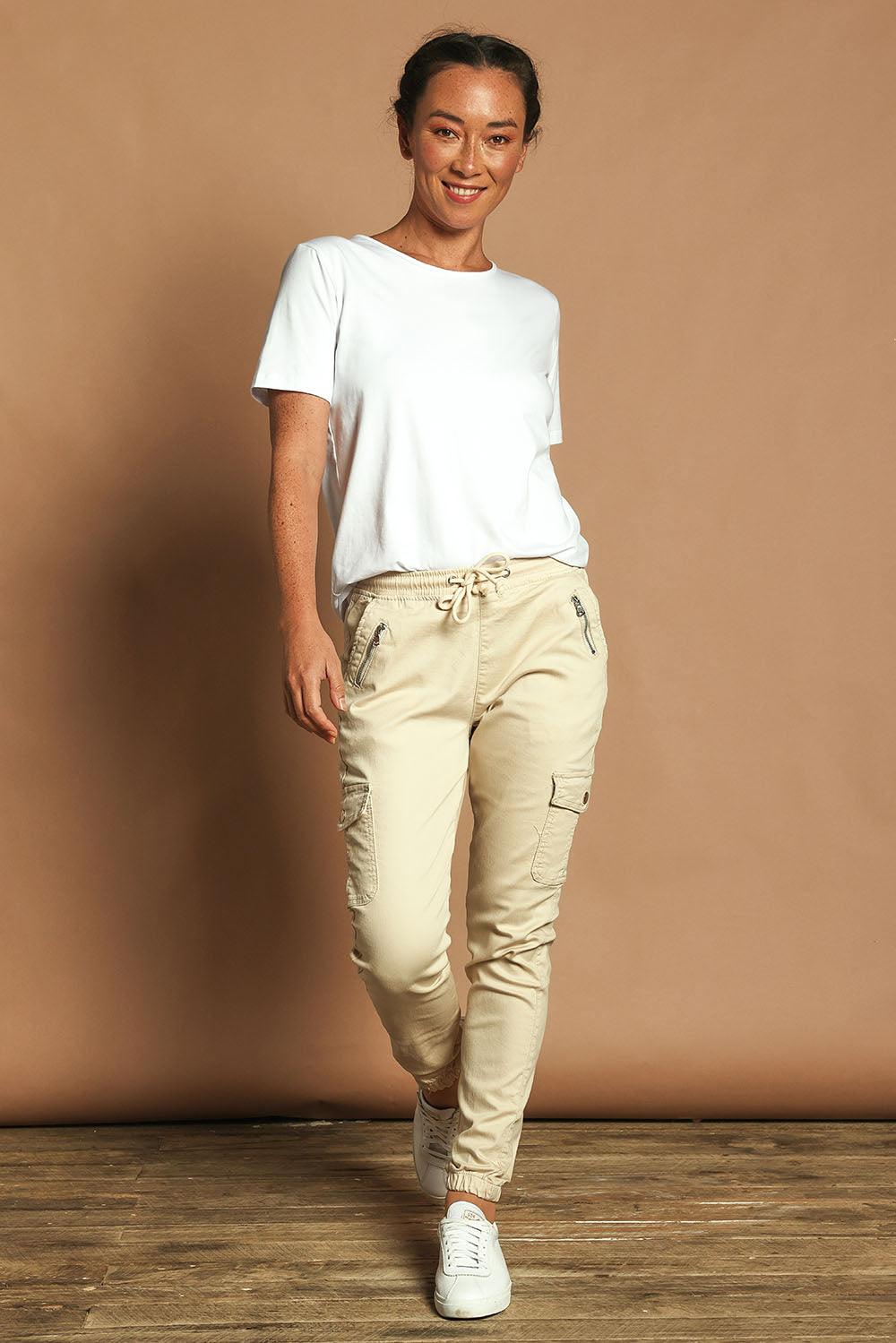 Model Katie wearing size 10 of the Harlow Cargo Jogger in colour Beige, from the front, showing the whole outfit