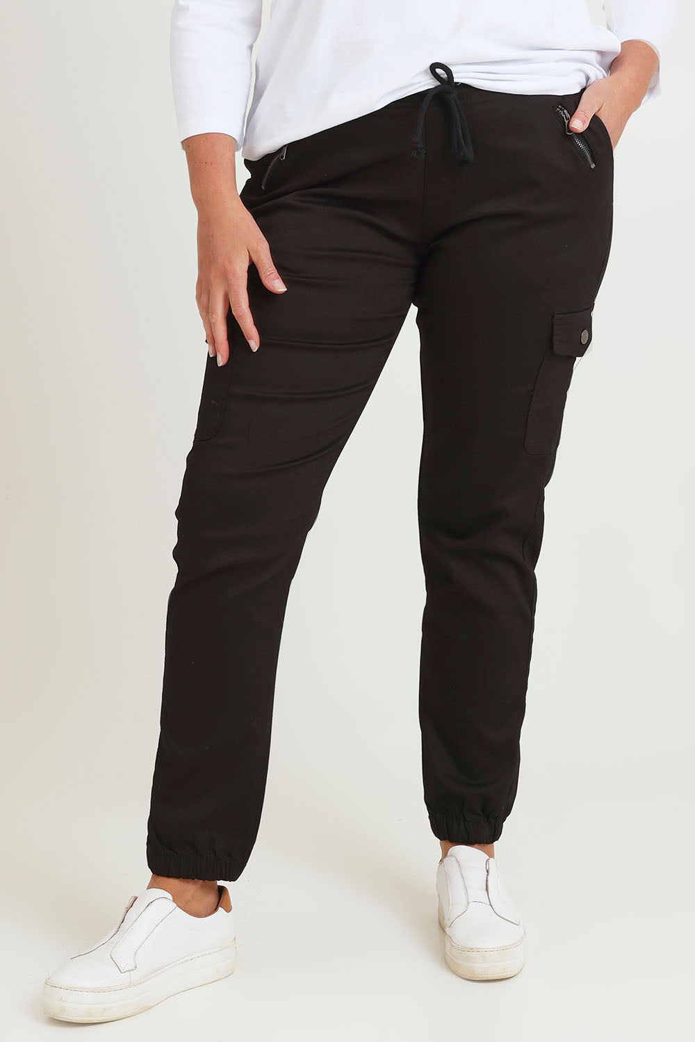 Model Chanel wearing size 16 of the Harlow Cargo Jogger in colour Black (Black), from the front, cropped image