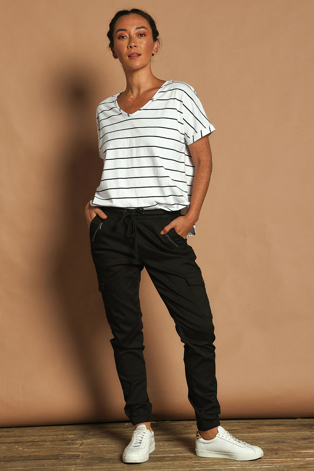 Model Katie wearing size 10 of the Harlow Cargo Jogger in colour Black (Black), from the front, showing the whole outfit
