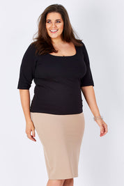Model Mae wearing size 16 of The Ponte Knee Length Pencil Skirt in colour Beige, from the front, cropped image