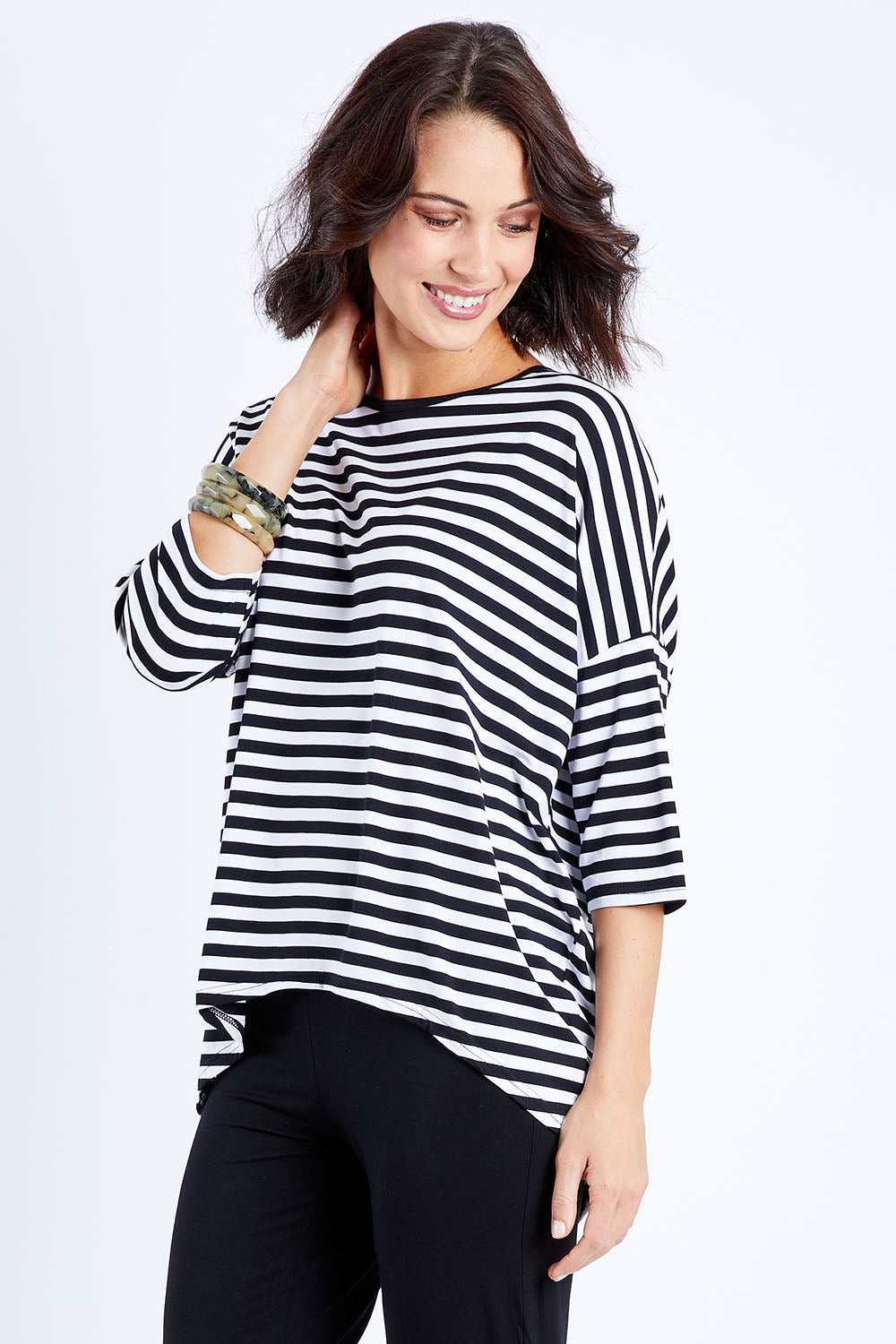 Model Andrea wearing size S of the Thin Stripe Bamboo Hi Low Top in colour Blackwhite (White), from the front, cropped image
