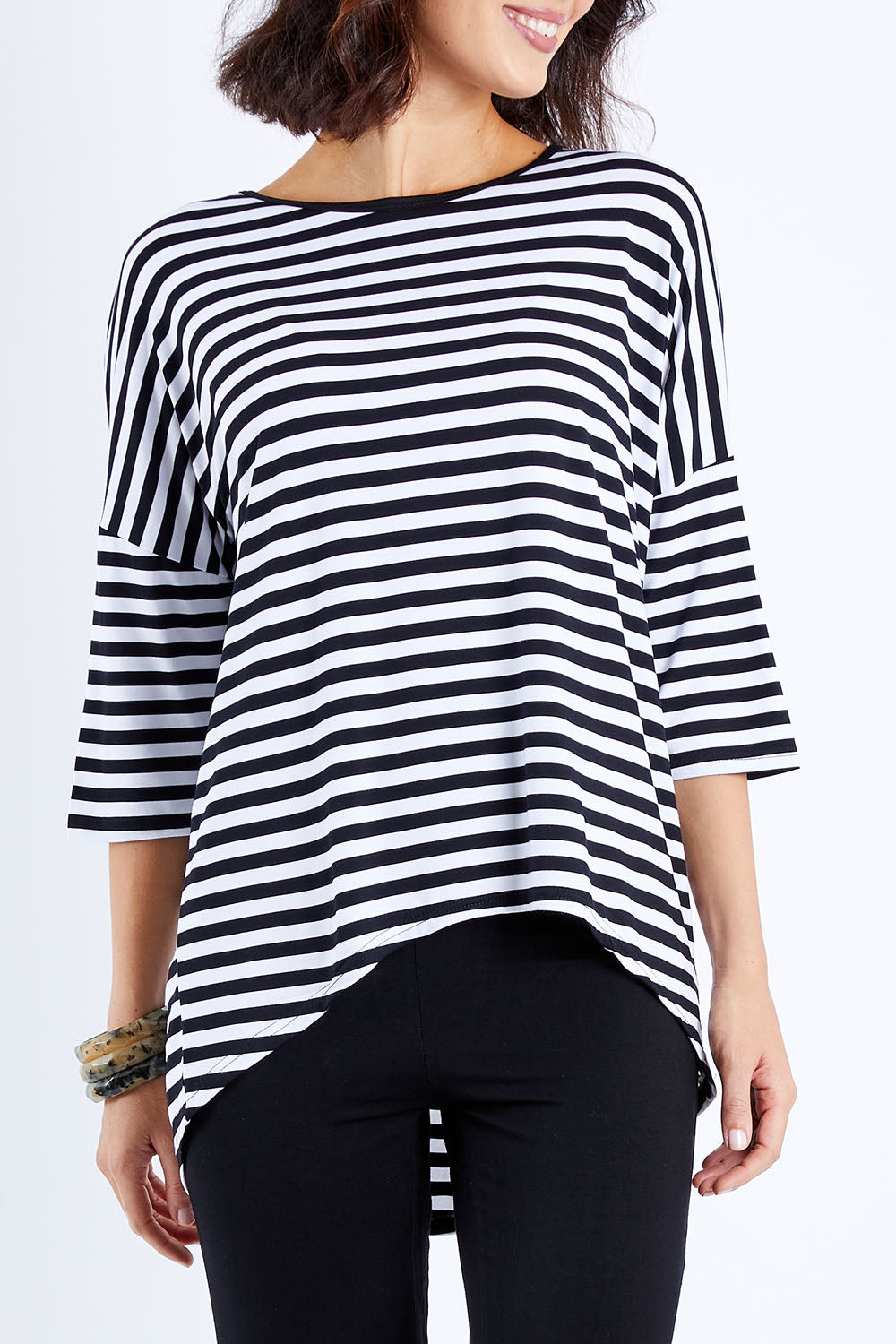 Model Andrea wearing size S of the Thin Stripe Bamboo Hi Low Top in colour Blackwhite (White), from the front, cropped image