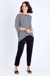 Model Andrea wearing size S of the Thin Stripe Bamboo Hi Low Top in colour Blackwhite (White), from the front, showing the whole outfit