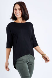 Model Andrea wearing size S of the Relaxed High Low Bamboo Top in colour Black (Black), from the front, cropped image