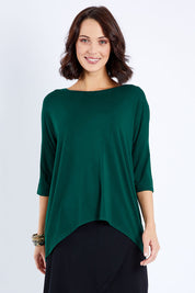 Model Andrea wearing size S of the Preloved Relaxed High Low Bamboo Top in colour Forest (Green), from the front, cropped image
