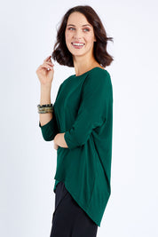 Model Andrea wearing size S of the Preloved Relaxed High Low Bamboo Top in colour Forest (Green), from the front, cropped image