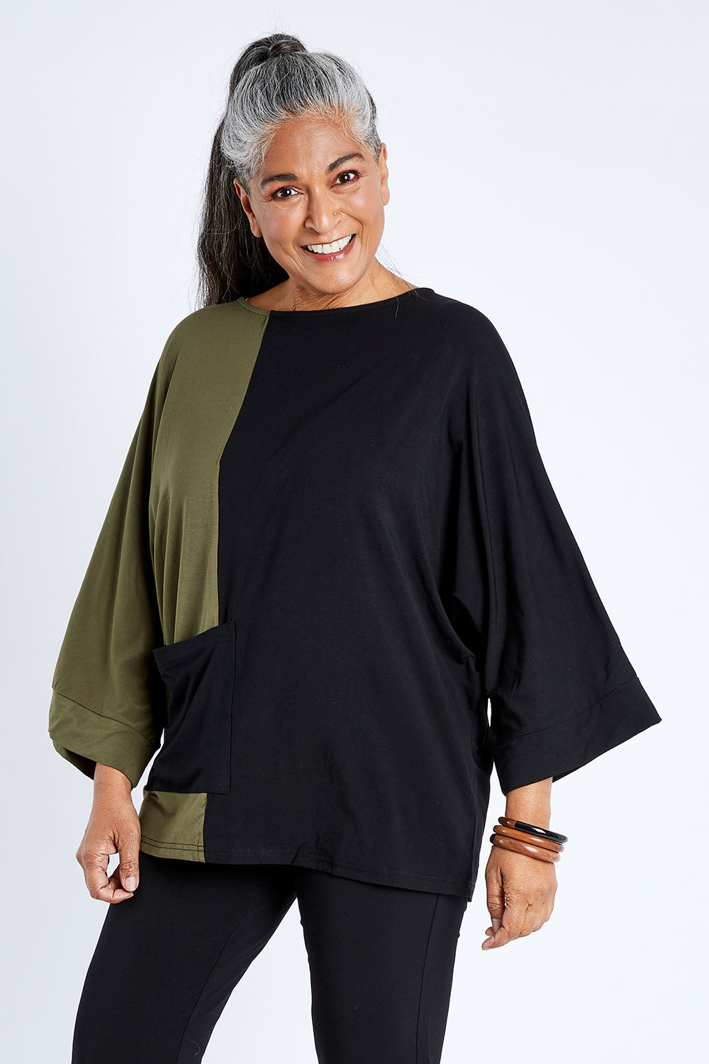 Model Nadine wearing the Two Tone Bamboo Oversized Top in colour Blkolive (Black), from the front, cropped image