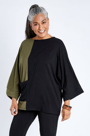Model Nadine wearing the Two Tone Bamboo Oversized Top in colour Blkolive (Black), from the front, cropped image