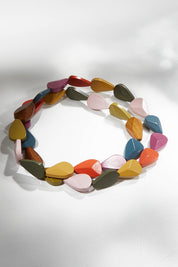 A model wearing size OneSize of the Koala Multi Necklace in colour Olive (Green), from the front, showing the whole outfit