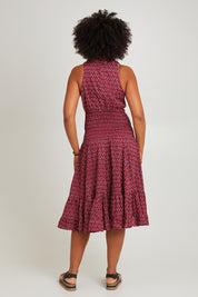 Model Olivia wearing size S-M of the Polly Tiered Dress in colour Corfu (Red), from the back