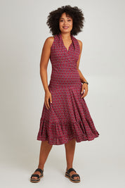 Model Olivia wearing size S-M of the Polly Tiered Dress in colour Corfu (Red), from the front, showing the whole outfit