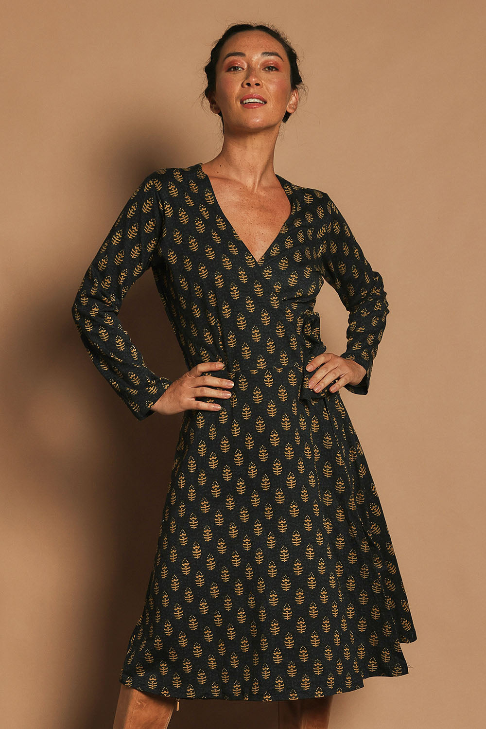 Model Katie wearing size S of the Sunburst Cotton Wrap Dress in colour Acton (Black), from the front, cropped image
